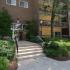 Entrance to brick and yellow apartment building with stairs and well maintained landscaping