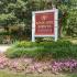 White and red Main Line Berwyn Apartments property sign surrounded by pink petunias