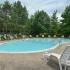 Swimming pool with lounge chairs and umbrellas at Valley Forge Suites in King of Prussia, PA.