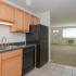 Kitchen with brown cabinets and black appliances at Concord Court apartments for rent in Aston, PA