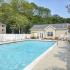 Outdoor swimming pool with lounge chairs and umbrellas at Cedar Tree Village apartments for rent in Wilmington, DE