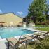 Outdoor swimming pool with lounge chairs and umbrellas at Fox Run apartments for rent in Warminster, PA