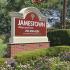 Red Jamestown Village Apartments sign surrounded by flowers