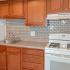 Kitchen with brown cabinets and white appliances at Chesapeake Village apartments for rent