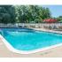 Sparkling pool at Phoenixville, PA apartment complex surrounded by chairs and umbrellas