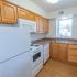 Kitchen with brown cabinets and white appliances at Allandale Village apartments for rent in Newark, DE