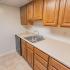 Model kitchen with wood cabinets and modern appliances at Park Court Apartments in Reading, PA.