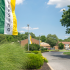 Entrance to Woodbury, NJ townhome community with landscaping and green and yellow leasing flags