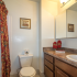 Apartment bathroom with brown vanity and colorful shower curtain