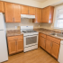 Model kitchen with wood cabinets and modern appliances at Polo Ridge apartments in Burlington, NJ.