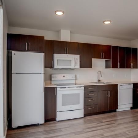 714 White Appliances & Dark Cabinetry in Kitchen | HANA Apartments | Apartments Seattle WA