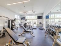 Fitness center with stationary bicycles, weight machines, medicine balls, and ceiling fans