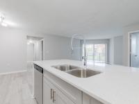 Newly renovated open concept kitchen with shaker style cabinetry and light sand plank flooring
