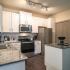 Apartments for Rent in West Nashville TN - Summit at Nashville West Apartments - Kitchen with Grainte-style Countertops, White Cupboards, Stainless Steel Appliances, and a Kitchen Island