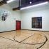 Indoor sports court with professional style flooring, high ceiling and mounted basketball goal