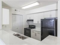 Kitchen with double sink and black refrigerator and oven