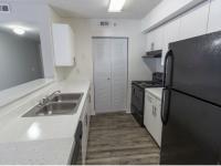 Kitchen with double sink, black refrigerator, oven, and dishwasher