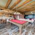 909 Flats Apartments Game Room with Billiard Table, Hanging Lights, Seating with Tables, Couches, and Wood-Inspired Plank Flooring