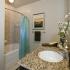 Bathroom with granite countertops and shelving