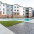 The Crockett - Pool Deck with Swimming Pool, Grass Area, BBQ Grills, and Seating.