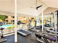 fitness center with exercise equipment and windows overlooking pool at Silver Creek Apartments