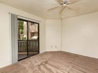 living room with brown carpet and ceiling fan and sliding door to patio at Silver Creek Apartments