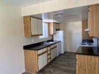 galley kitchen with white appliances and vinyl wood like flooring at monterey apartments