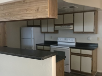 kitchen with breakfast bar and white appliances and vinyl wood like flooring at monterey apartments
