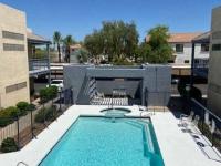 view of gated pool with chairs and lounge chairs from second floor at Monterey Apartments