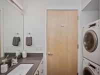 bathroom with stacked washer and dryer at oro apartments