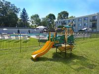 Arbor Lane exterior property grounds playground and pool on sunny summer day