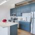 Blue cabinet kitchen with white quartz countertop.