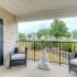 Balcony with outdoor furniture and peaceful statue at The Landings at Chandler Crossings | Off-Campus Housing Near MSU.