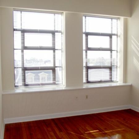 Living room with bright windows at Sydnor Flats Apartments