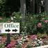 Marcell Gardens Apartments, Sign pointing to office, Flowers in flower bed with trees, stairs