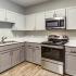 Kitchen with stainless steel appliances and grey cabinets