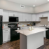 Kitchen with black appliances and white cabinets