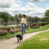 girl walking dog by lake