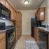 Coryell Courts furnished kitchen with black appliances