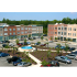 exterior apartment buildings with fountain and parking lot on sunny day