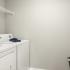 Laundry room with side by side washer and dryer and wire shelves