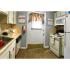 Kitchen area: Stainless steal Double sink with sprayer, White interior door with window and nice kitchen curtain, White counter tops and cabinets, White appliance package, Hardwood-look flooring.