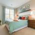 Spacious bedroom with a large window and carpeting at Prospect Hall Apartments