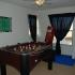 A foosball table and punching bag in a dimly lit room. | Tierra Vista Communities Houses for rent, Schriever SFB, Colorado Springs CO