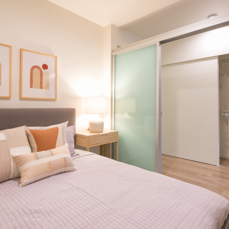Bedroom with sliding privacy door in an apartment at Modera Broadway.
