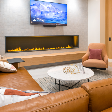 Luxurious lounge and lobby space with leather sofa and fireplace  at Modera Broadway apartments in Seattle.