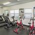 The Lodge at Woodlake apartments, interior, fitness center, elliptical machine, 2 treadmills, 2 red stationary bikes