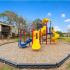 The Loop at Wedgewood exterior: playground, large tress, and well-maintained landscaping