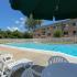 Community swimming pool with umbrellas and lounge chairs at Mill Creek Village apartments in Langhorne, PA.