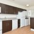 Updated kitchen with hardwood floors, white appliances, and stackable washer and dryer
